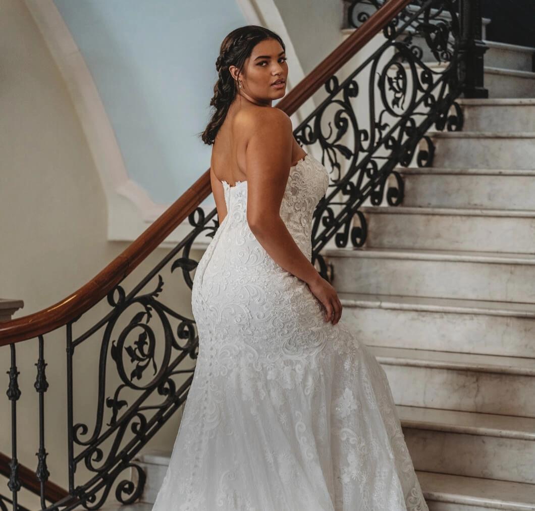 Plus-size Model in a wedding gown walking up stairs