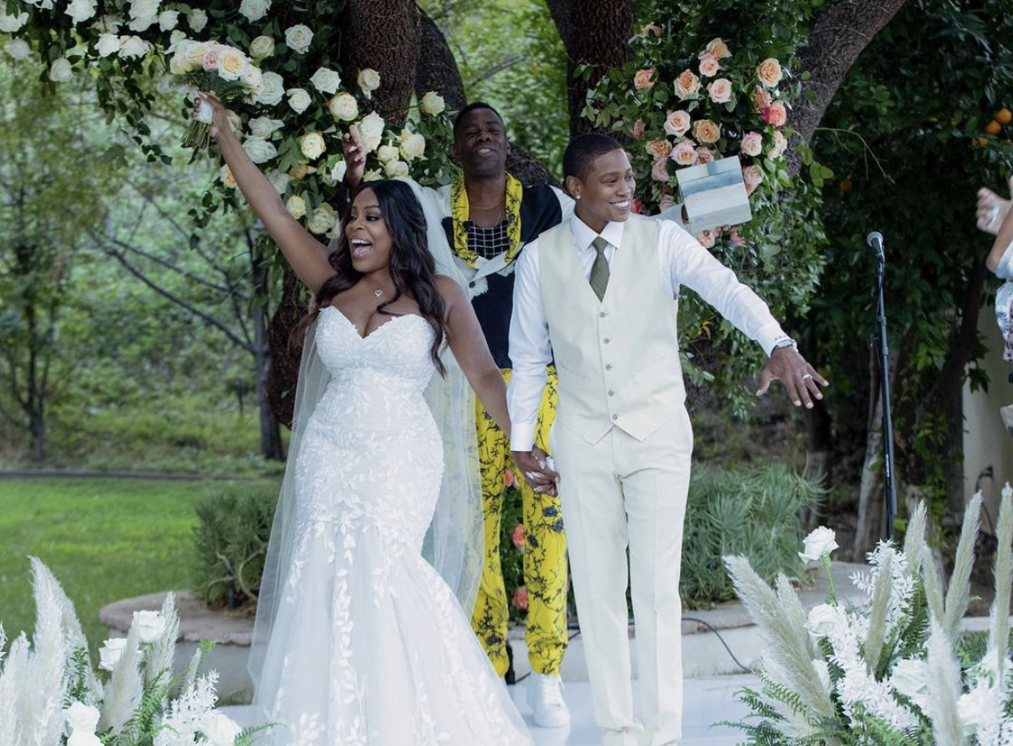 Brunette bride in white dress together with groom in light wear walking